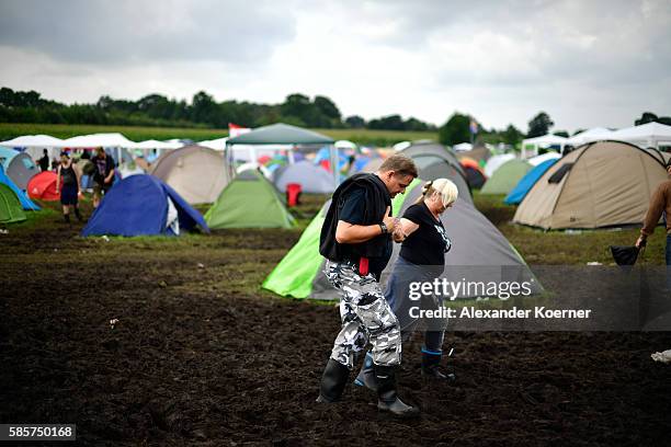 Fetsival goers walk through mud on the camping site during the Wacken Open Air festival on August 4, 2016 in Wacken, Germany. Wacken is a village in...