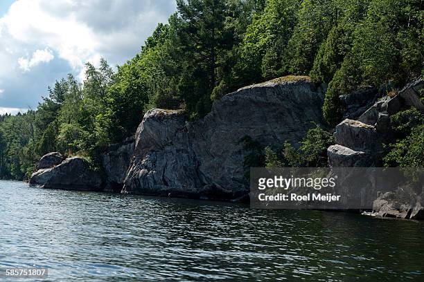 rockface along swedish lake - dalsland stock pictures, royalty-free photos & images