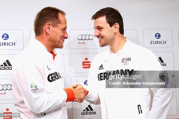 Alfons Hoermann, president of the German Sports Confederation shake hands with table tennis player Timo Boll as he is announced as flag bearer for...