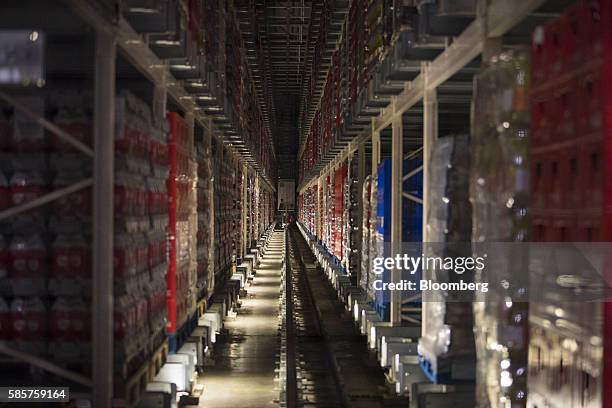 Soft drink cans and bottles sit on sealed pallets in a storage room following manufacture at the Coca-Cola Co. Factory in Dongen, Netherlands, on...