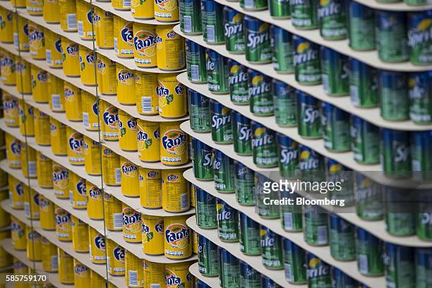 Cans of lemon Fanta and Sprite soft drink sit stacked on pallets in a storage area following manufacture at the Coca-Cola Co. Factory in Dongen,...
