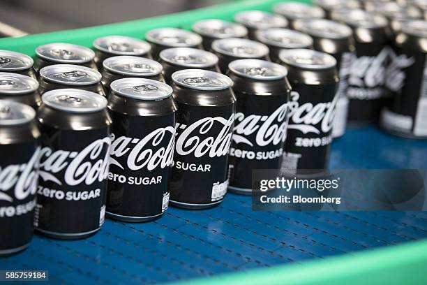 Sealed cans of Coke Zero sugar free soft drink move along a conveyor following manufacture at the Coca-Cola Co. Factory in Dongen, Netherlands, on...