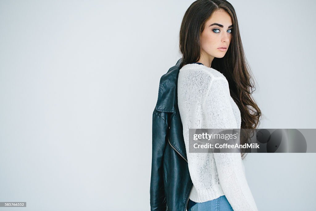 Beautiful girl holding leather jacket