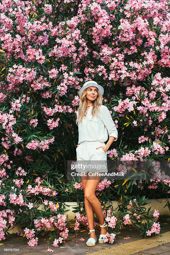 Hermosa chica en el fondo de primavera arbusto