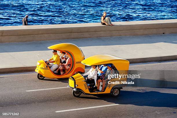 coco taxis driving along the malecon in havana, cuba - coco stock pictures, royalty-free photos & images