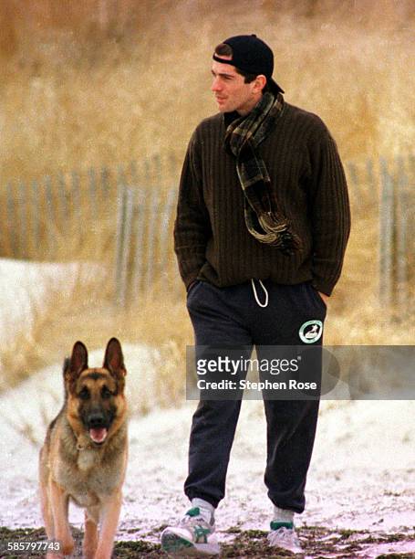 John F. Kennedy Jr. Looks out to sea while walking with his dog along the beach in Hyannis Port, Massachusetts, the day after his grandmother Rose...