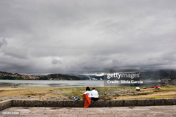 couple looking the low tide in combarro, concejo de poio, rias bajas, pontevedra, galicia - descansar stock pictures, royalty-free photos & images