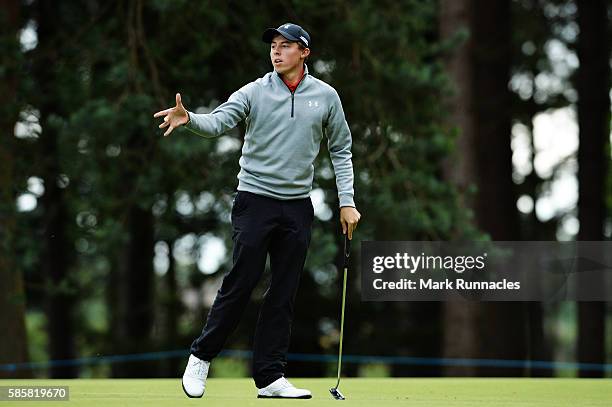 Matthew Fitzpatrick of England throws Thomas Bjorn of Denmark back his ball marker on the green of hole 7 on day one of the Aberdeen Asset Management...