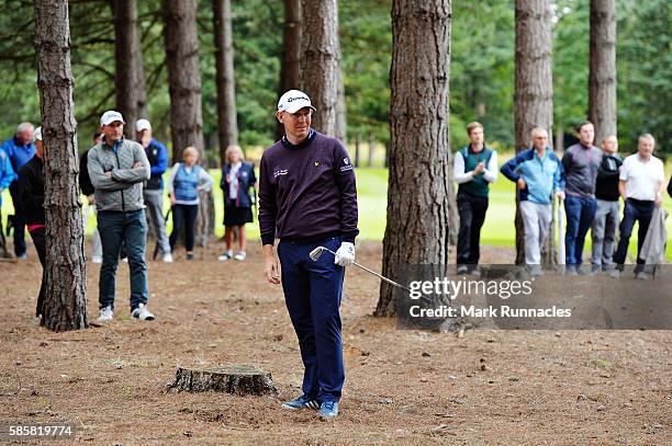 Stephen Gallacher of Scotland looks on from the trees next to the fairway on hole 2 on day one of the Aberdeen Asset Management Paul Lawrie Matchplay...