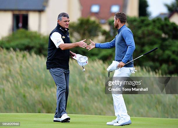 Paul Lawrie of Scotland is congratulated after winning his match against Lucas Bjerregaard of Denmark on day one of the Aberdeen Asset Management...