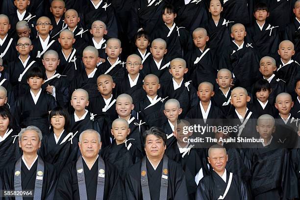 Children with shaven head wearing Kesa, monk costume attend a ceremony to become Buddhist monks at Higashi Honganji temple on August 4, 2016 in...