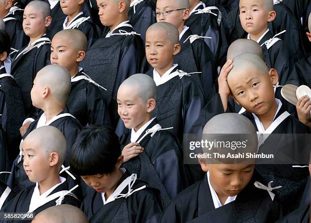 Children with shaven head wearing Kesa, monk costume attend a ceremony to become Buddhist monks at Higashi Honganji temple on August 4, 2016 in...