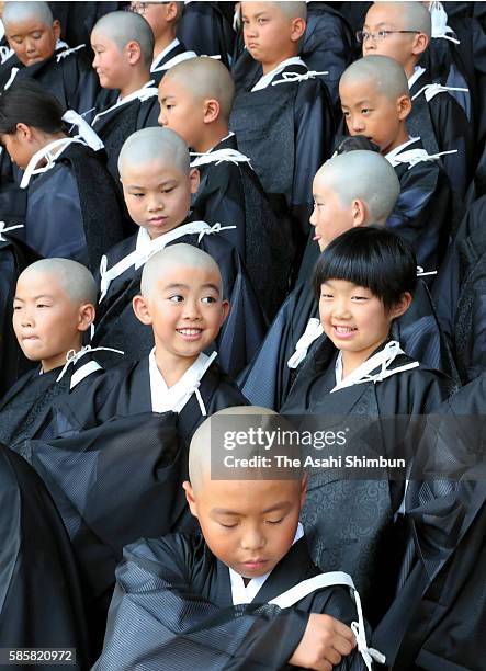 Children with shaven head wearing Kesa, monk costume attend a ceremony to become Buddhist monks at Higashi Honganji temple on August 4, 2016 in...