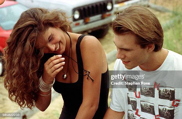 Host Daisy Fuentes with actor Christian Slater during the filming of Beach MTV at the Beachcomber in Wellfleet, Massachusetts, 29th July 1990.