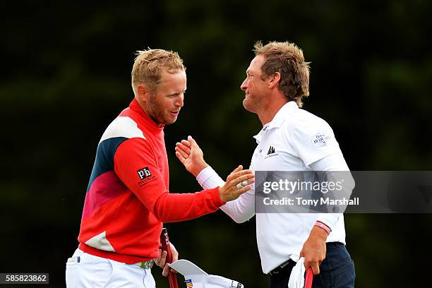 Matt Ford of England shakes hands with Pelle Edberg of Sweden after winning their match on the green at hole 16 on day one of the Aberdeen Asset...