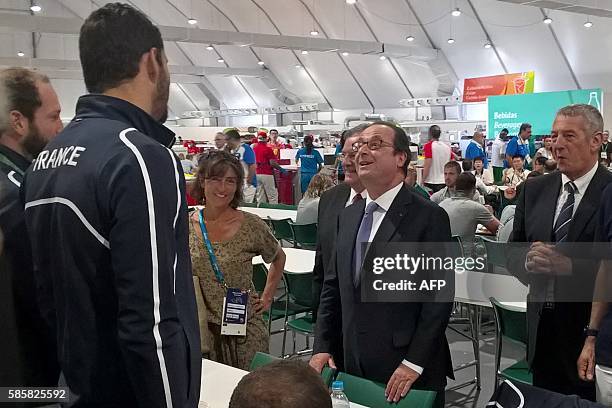 French President Francois Hollande and his councillor for sports Nathalie Iannetta meet with French swimmer Florent Manaudou at the Athletes' Village...