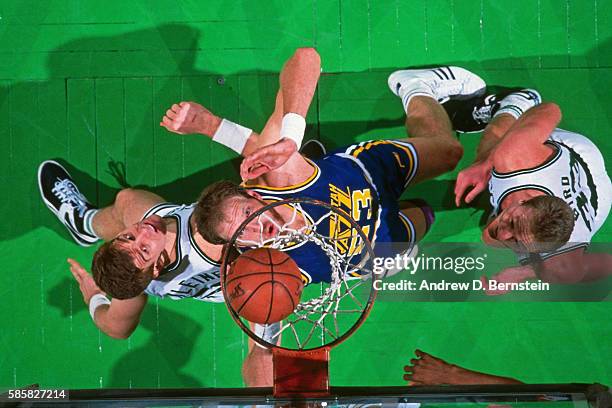 Mark Eaton of the Utah Jazz boxes out Joe Kleine and Larry Bird of the Boston Celtics during a game at the Boston Garden in Boston, Massachusetts...