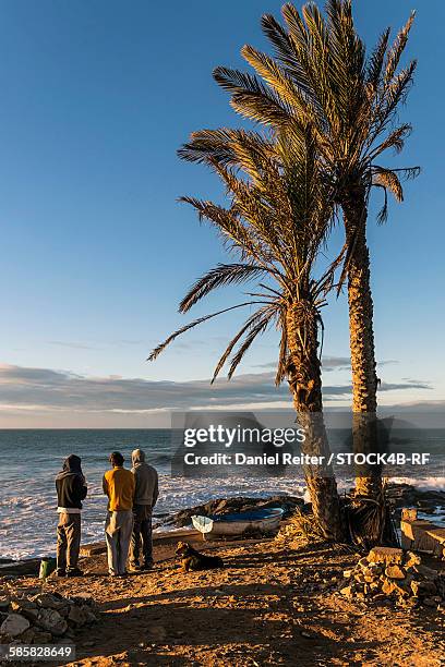 friends standing at the coast looking at the ocean, essaouira, morocco - travel african sunset rf photos only stock pictures, royalty-free photos & images