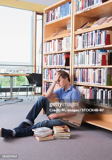 exhausted teenage boy in library - a level stock pictures, royalty-free photos & images