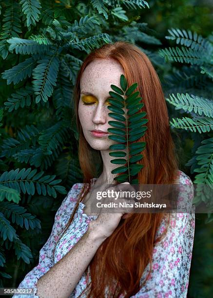 red haired young woman with eyes closed in nature - pale complexion stock-fotos und bilder