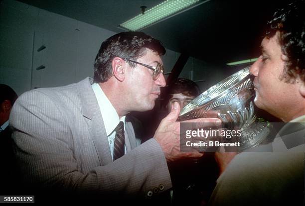 Canadian-born hockey coach and former professional hockey player Al Arbour, head coach of the New York Islanders, drinks champagne out of the Stanley...