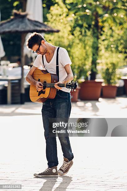 young man playing guitar on the street - busker 個照片及圖片檔