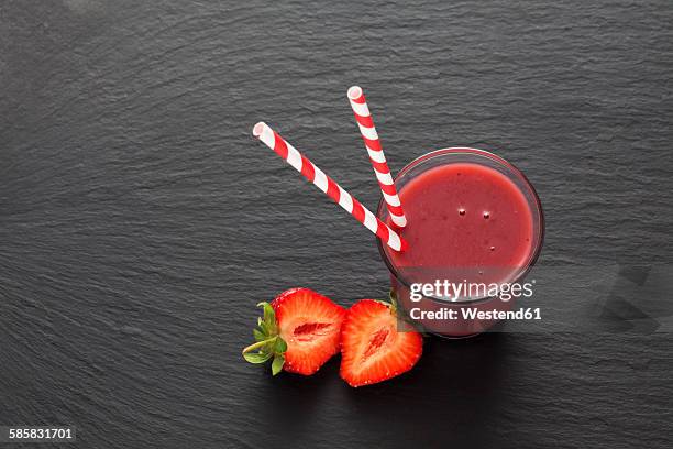 glass of strawberry smoothie and sliced strawberry - schist stock-fotos und bilder