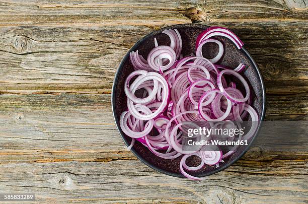 bowl of sliced red onions on wood - gemüsezwiebel stock-fotos und bilder