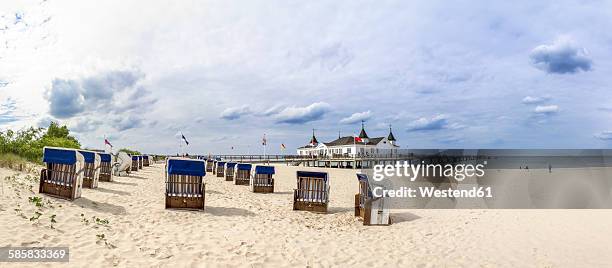 germany, ahlbeck, view to sea bridge with hooded beach chairs on the beach in the foreground - usedom fotografías e imágenes de stock