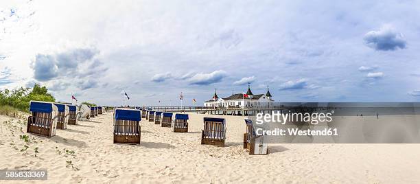 germany, ahlbeck, view to sea bridge with hooded beach chairs on the beach in the foreground - usedom photos et images de collection