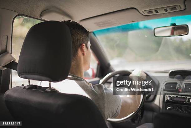 young man driving car - repose tête photos et images de collection