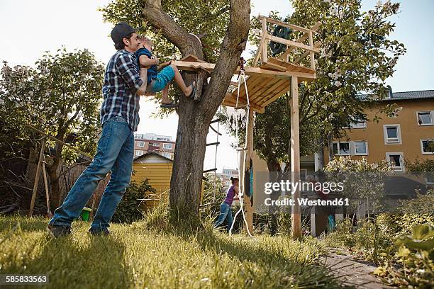 family playing in garden at tree house - treehouse like stock pictures, royalty-free photos & images