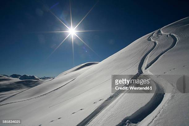 austria, kitzbuehel, snow with ski tracks against the sun - marca de esqui - fotografias e filmes do acervo