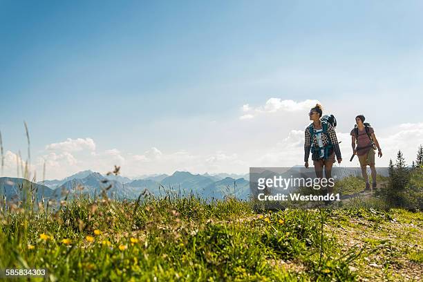 austria, tyrol, tannheimer tal, young couple hiking on mountain trail - tyrol state stock pictures, royalty-free photos & images