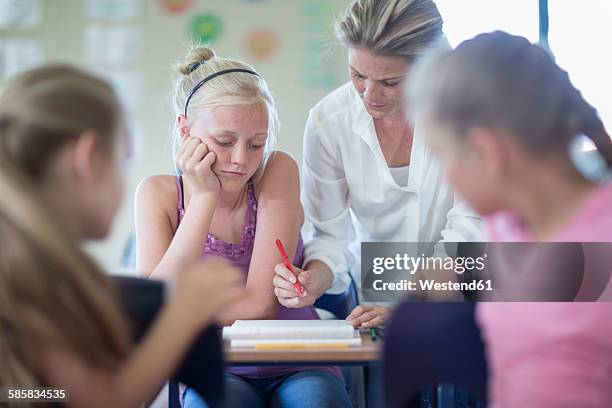 teacher correcting schoolgirl's bad test - bad kids classroom stockfoto's en -beelden