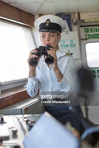deck officer on ship holding binoculars - chapéu de marinheiro imagens e fotografias de stock