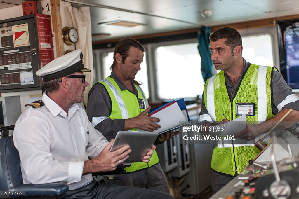 Ship crew and captain on bridge