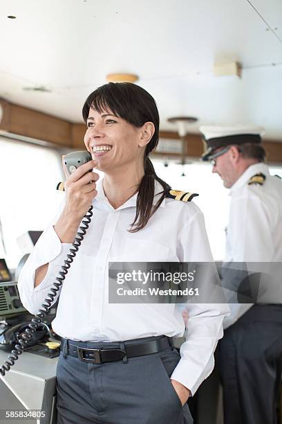 smiling chief mate on bridge talking on radio - boat captain 個照片及圖片檔