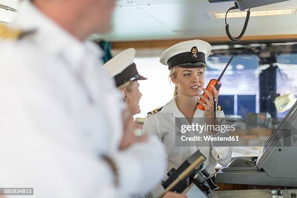 deck officer on bridge talking on radio - chapéu de marinheiro imagens e fotografias de stock