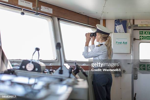 deck officer on ship looking through binoculars - sailor hat 個照片及圖片檔
