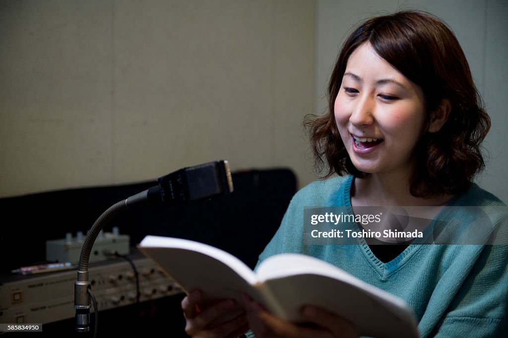 A voice actrees recording her voice at recording studio
