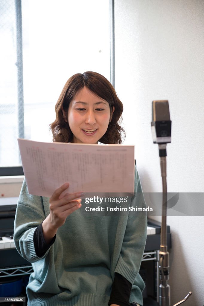 A voice actrees recording her voice at recording studio