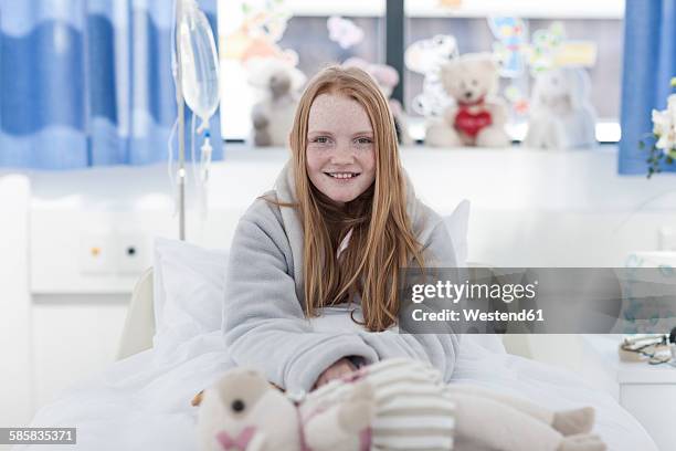 portrait of smiling girl with red hair in hospital bed - girl in hospital bed sick stock pictures, royalty-free photos & images