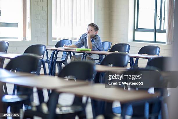 schoolboy alone in classroom - punizione foto e immagini stock