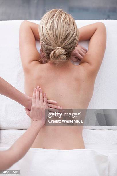 young woman getting a back massage in a spa - woman massage stock pictures, royalty-free photos & images