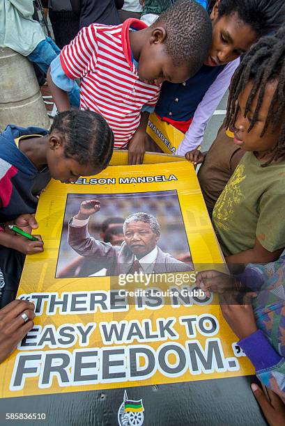 Vilakazi Street, Soweto, South Africa: South African children react to the passing of Nelson Mandela, signing their names and wishes on placards of...