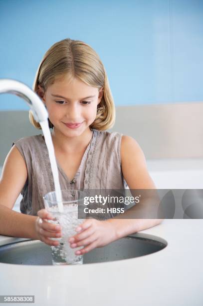 girl filling a glass with water - girl filling water glass stock pictures, royalty-free photos & images