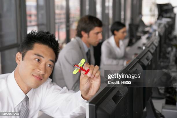 businessman with toy airplane - person surrounded by computer screens stock-fotos und bilder