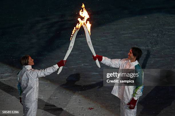 Basketball star Steve Nash receives the flame from former Canadian speed skater Catriona LeMay Doan and carries the Olympic torch as the final...