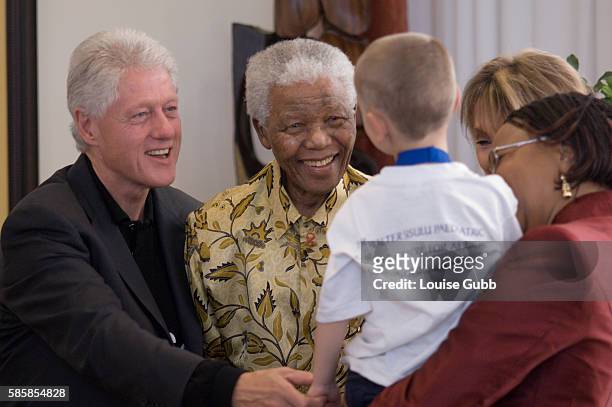 Heart patient Chris Ferreira greets former Presidents Bill Clinton and Nelson Mandela at the Walter Sisulu Paediatric Cardiac Centre for Africa, at...